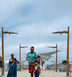 ein Mann und seine Familie gehen auf einem Pier spazieren