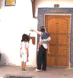 一名妇女抱着孩子站在门前