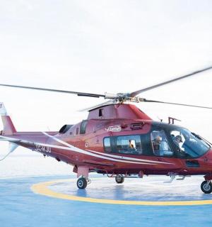 a red helicopter is sitting on a runway