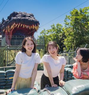 三个女孩站在主题公园的充气鳄鱼上