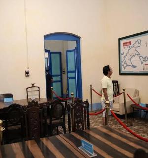 一名男子站在房间里，戴着红丝带