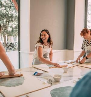 一群人围坐在桌旁揉面团