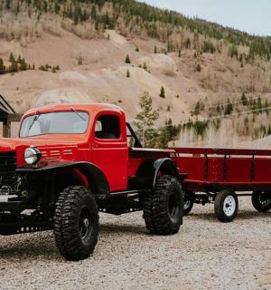 an old red truck parked next to a building