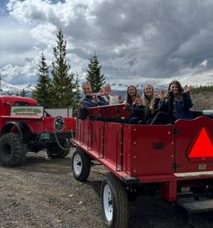 skupina lidí jedoucích v červeném kamionu