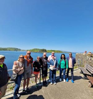 a group of people standing on a wall near the water