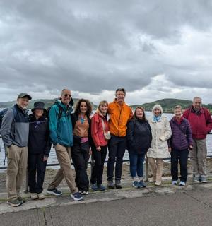 a group of people posing for a picture by the water