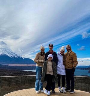 a group of people standing in front of a mountain