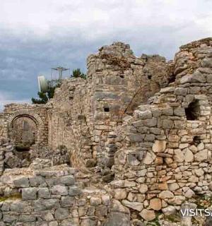 an old stone building on top of a hill