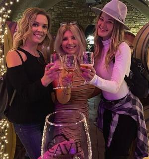 tři ženy držící sklenice na víno na večírku