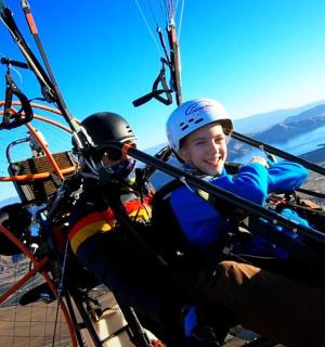 two boys are riding a gondola in a parachute