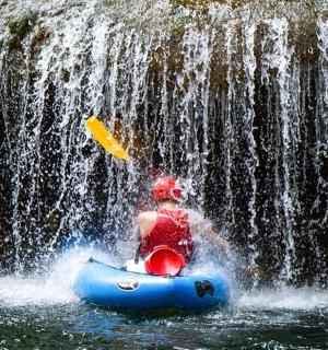 en mand i en tømmerflåde foran et vandfald