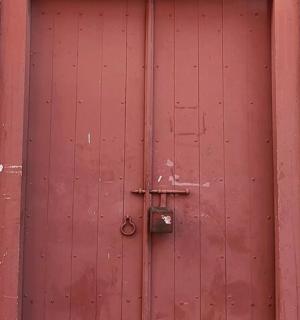 a red wooden door with a lock on it