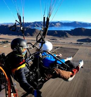 two people are riding a parachute in the sky