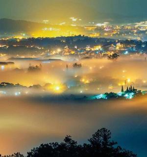 a view of a foggy city at night with lights