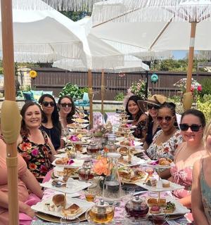 a group of women sitting around a table with food