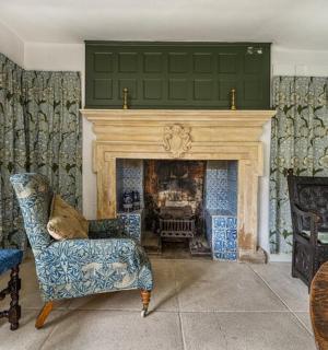 a living room with a fireplace and a chair and a table