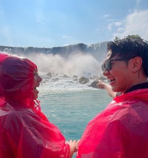 两个穿着红色夹克的人站在瀑布前