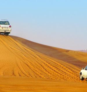 două mașini pe o dună de nisip în deșert