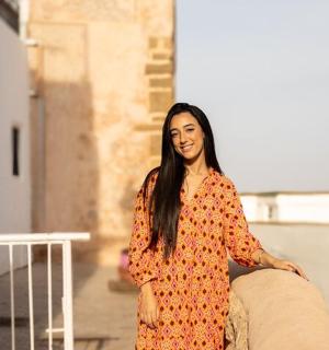 一位身穿橙色连衣裙的女士坐在沙发上