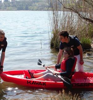 一组三人乘坐一艘红色皮划艇在水中