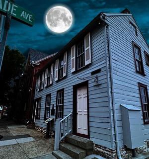 a white house with a white door and a street sign