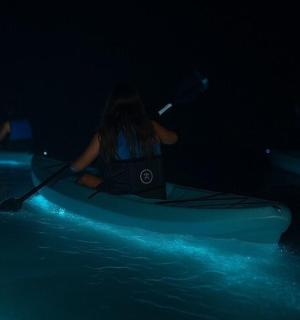 夜间,一名女子在水中划皮艇