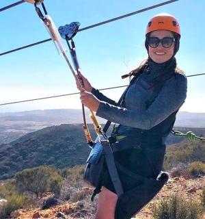 a woman on a zip line on a mountain
