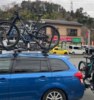 一辆蓝色汽车的车顶上放着两辆自行车