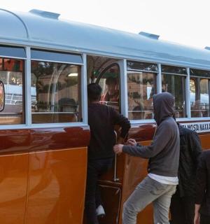 skupina lidí nastupujících do autobusu