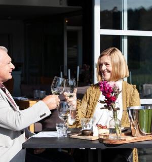 一男一女坐在桌边，手捧酒杯