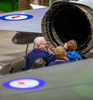 a group of people looking into the engine of an airplane