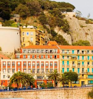 a building on the side of a hill with palm trees