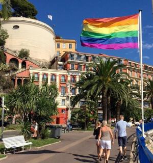a rainbow flag flying in front of a building