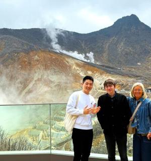 a group of people standing in front of a mountain