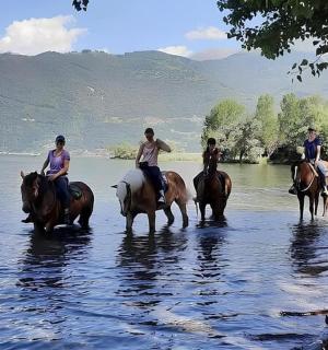 un gruppo di persone a cavallo nell'acqua
