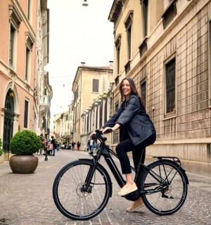 žena jedoucí na kole po městské ulici