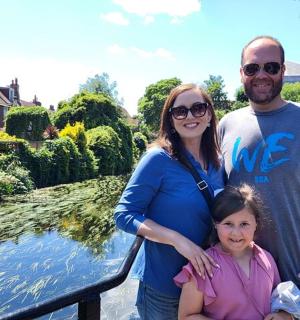 一名男子和一名女子站在一个小女孩旁边