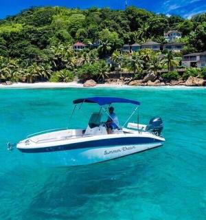 a white boat in the water near a beach