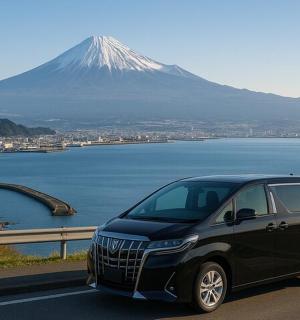 černé SUV jedoucí po silnici s horou v pozadí