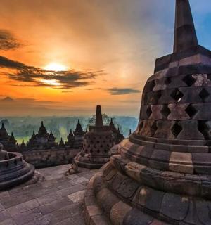 a group of temples with the sunset in the background