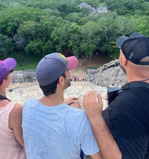 三个人站在岩石上望着河流