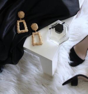 一位身穿黑色连衣裙、高跟鞋和项链的女士