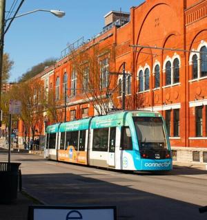 Modrobílý autobus jedoucí po městské ulici