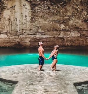 mies ja nainen seisovat kivellä vedessä