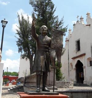 一座站在建筑物前的女人雕像