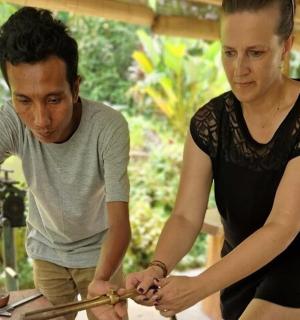 a man and a woman holding tongs at a table