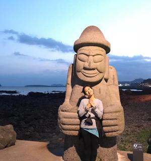 一位女士站在一座巨大的雕像前