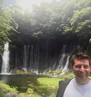 一名男子站在瀑布前