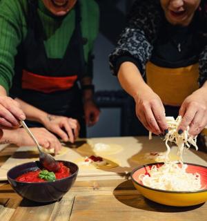 a group of people standing around a table preparing food