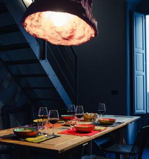 a dining table with wine glasses and a light